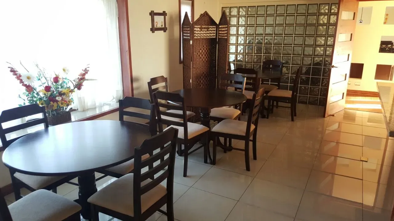 Comedor con mesas redondas de madera y flores sobre la mesa